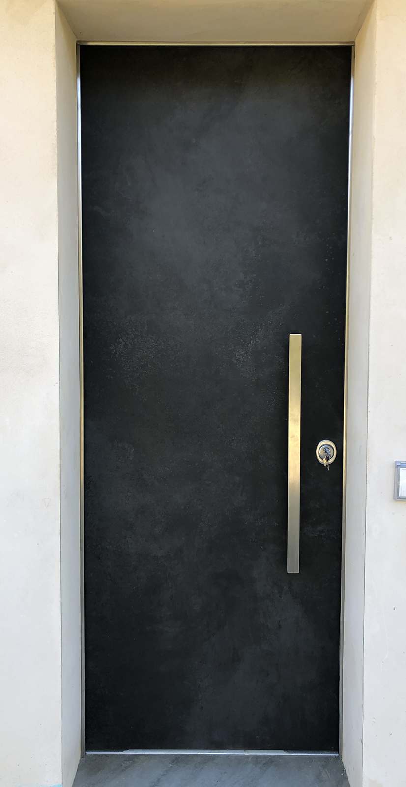 Porta blindata nera Securnova con maniglione verticale installata in abitazione moderna